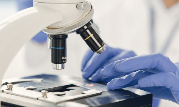 Medical staff looking at samples under a microscope